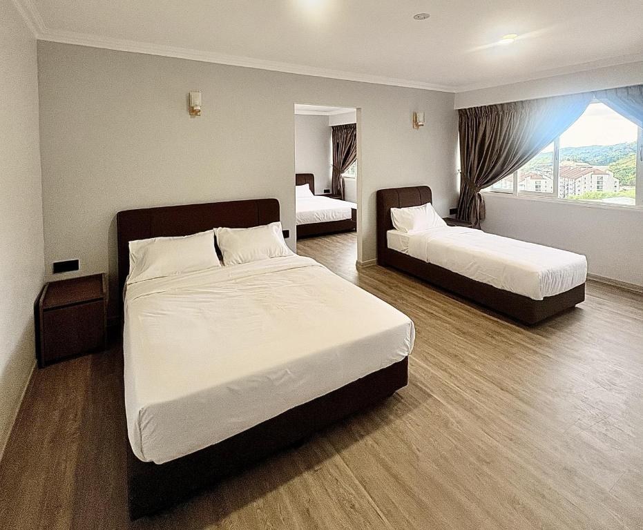 a hotel room with two beds and a window at Kea Garden Guest House in Brinchang