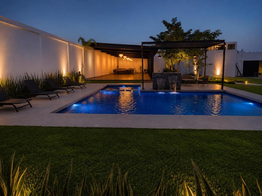a backyard with a swimming pool at night at Lucmar Jardín boutique in Cuernavaca