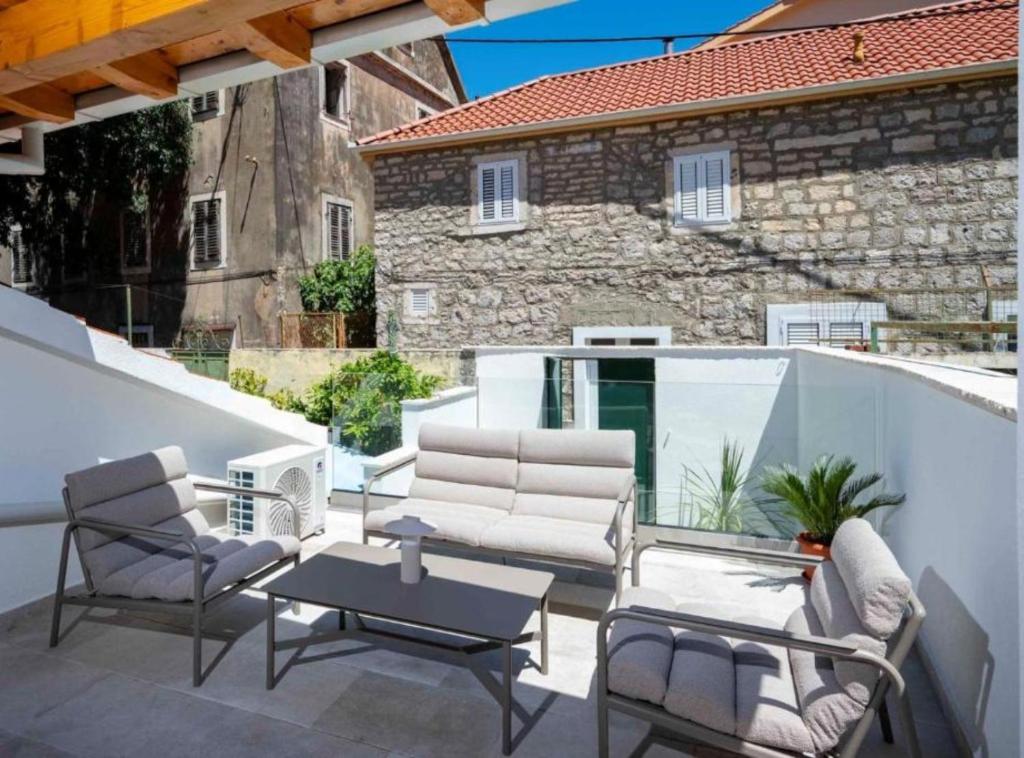 a patio with chairs and a table and a building at Apartman Dolce in Trpanj