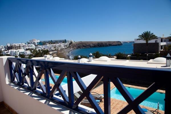 een balkon met een tafel en uitzicht op de oceaan bij Villas Coloradas in Playa Blanca