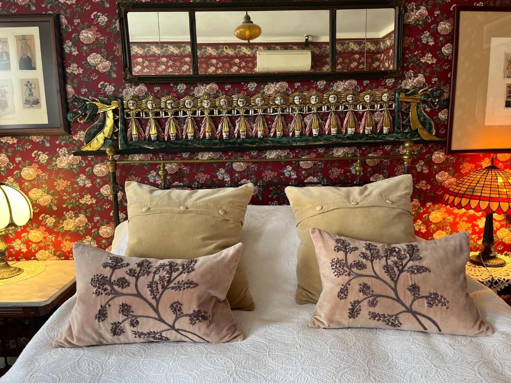 a bedroom with a bed with pillows and a mirror at Munroe Inn Boutique Hotel in Auburn