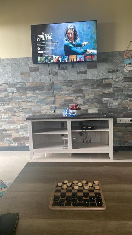 a living room with a flat screen tv on a stone wall at The Chill Spot in Mo Bay in Crooked River