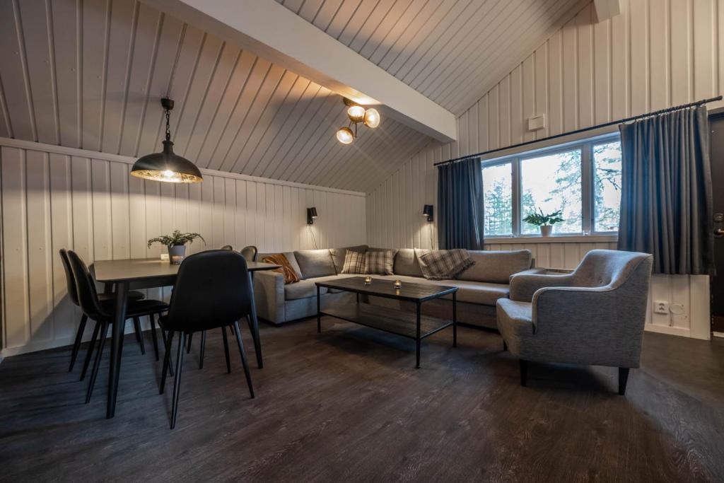 a living room with a couch and a table and chairs at Bruna Byn in Sälen