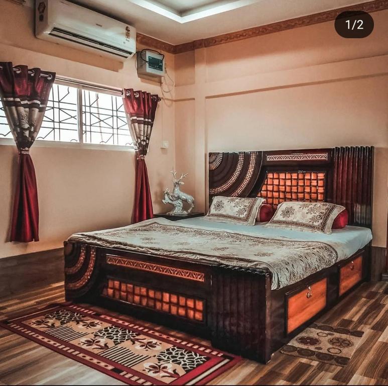 a bedroom with a large bed and a window at Madhuban Resort in Silchar