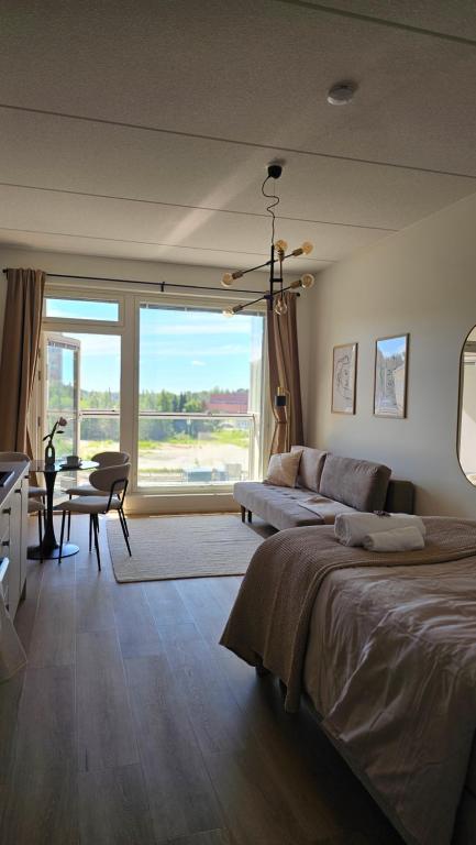 a bedroom with a large bed and a large window at Fabbrica's new and elegant apartment in Turku