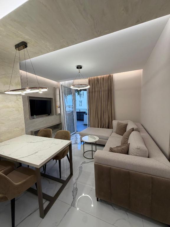 a living room with a couch and a table at Merxhan`S Apartment in Golem