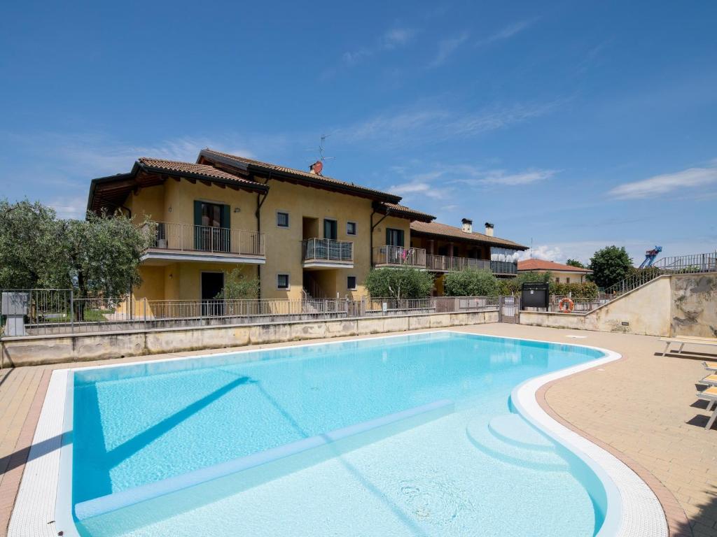 a swimming pool in front of a house at Snug Holiday Home in Lazise with Heating, near Lake Garda in Lazise