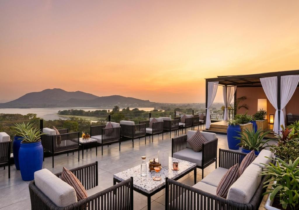 a hotel patio with tables and chairs and a view at The Sierra - By The Lake in Udaipur