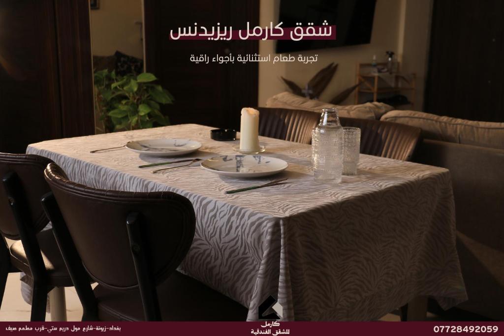 a table with a white table cloth and a candle on it at Carmel Residence - كارمل ريزيدنس in Baghdād
