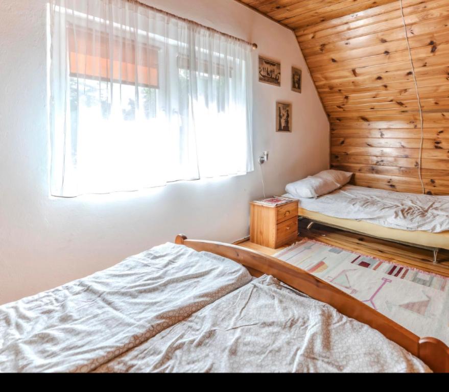 a bedroom with two beds and a window at Domki na Olszynki in Okuninka