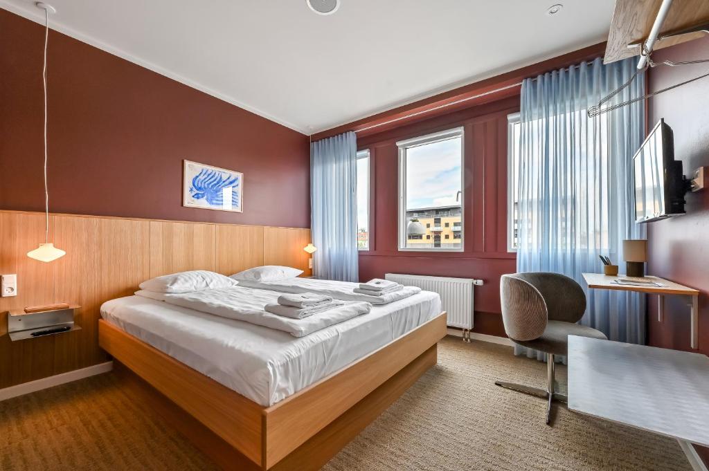 a bedroom with a bed and a desk and a chair at The Break Hotel in Herning