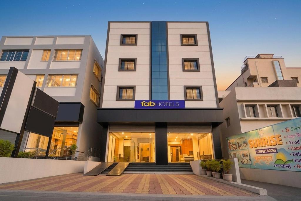 a building with a sign on the front of it at FabHotel Sunrise Comforts in Pune