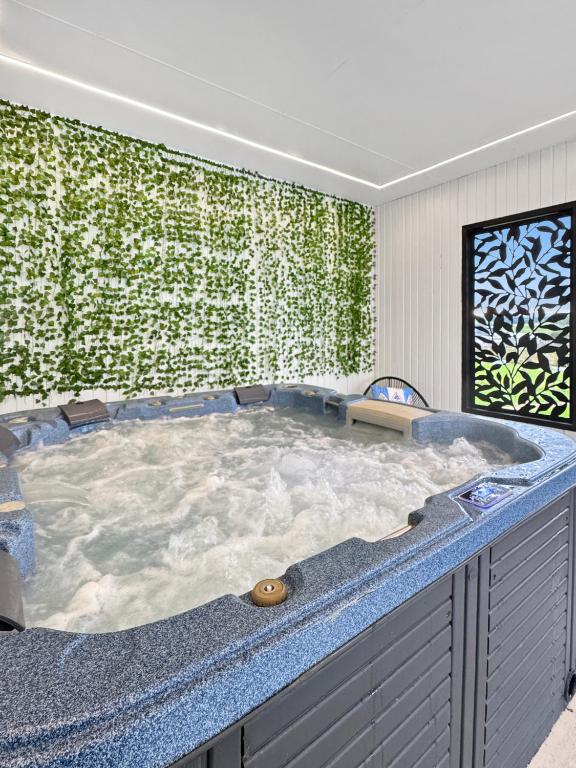 a jacuzzi tub in a room with a green wall at Coastal Sanctuary, Spa, EV friendly, Pet Firendly with Fireplace, wood provided Just 50m to Kilcunda Beach and 100m to the Ocean View Hotel The Sticks and Copper Door Kitchen Accessibility Friendly in Kilcunda