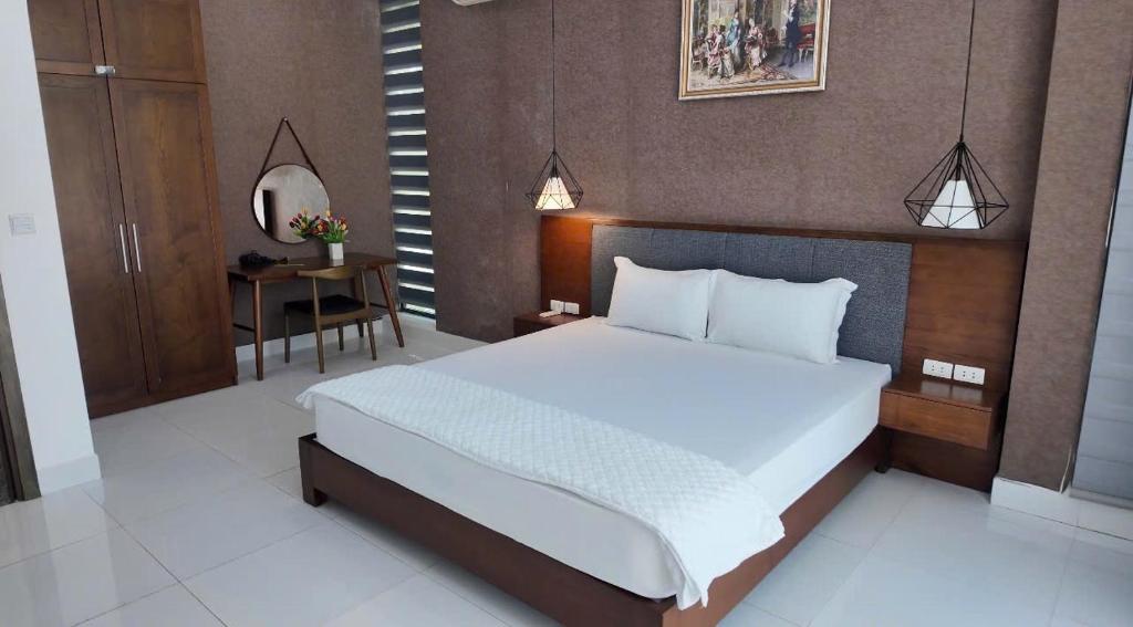 a bedroom with a large bed and a table at Ivory Villas & Resort - Villa view hồ Lake View in Rống Vong