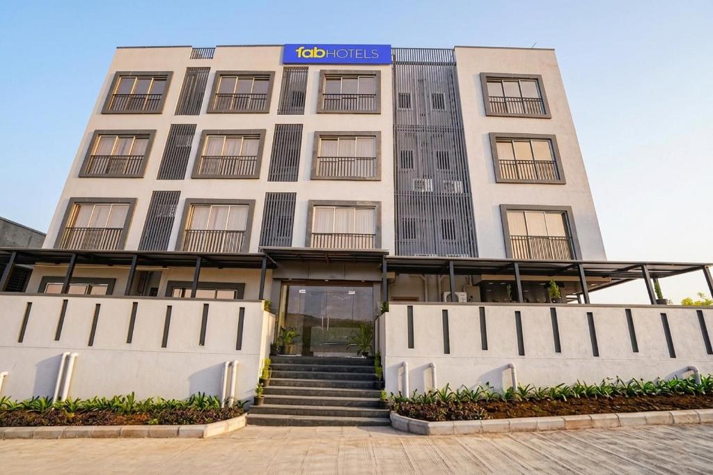 a large building with stairs in front of it at FabHotel Sahyadri Mantram in Pune