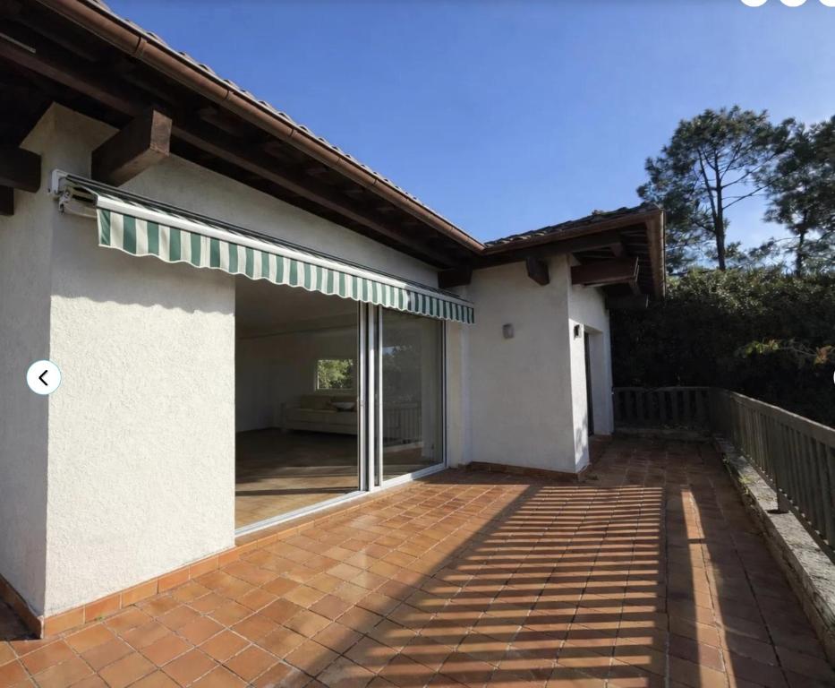 a house with a large glass door on a patio at Beach house within walking distance in La Teste-de-Buch