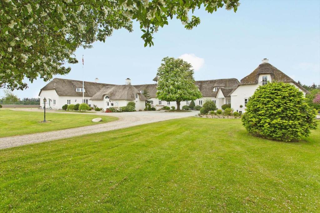 a large white house with a grass yard at HS025-Outrup-Strandvejen-31-B in Henne