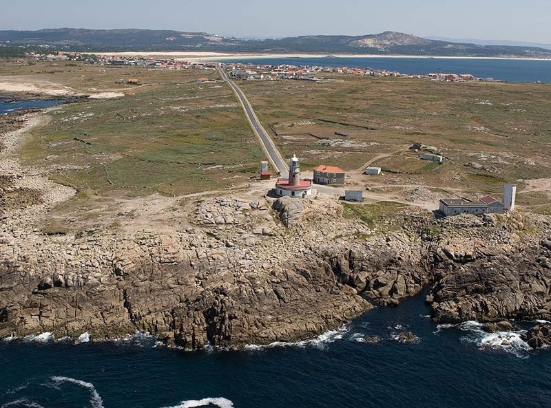 an island in the ocean with a lighthouse on it at Hostal Balieiros Corrubedo in Corrubedo