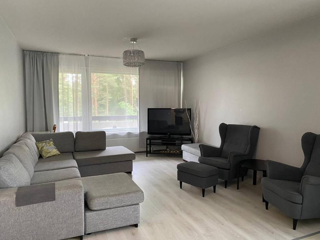 a living room with a couch and two chairs and a television at Just home in Hamina