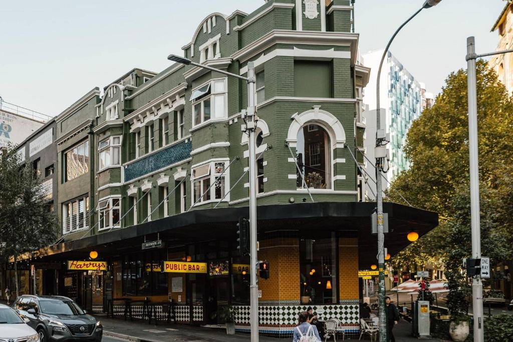 a green and white building on a city street at Hotel Harry, an Ascend Collection Hotel in Sydney