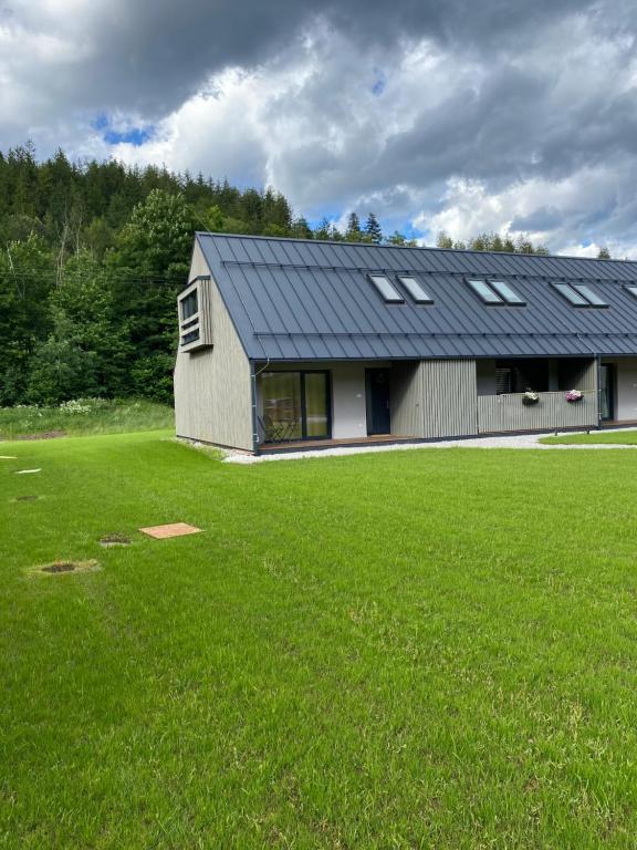 a house with a large green field in front of it at Apartmán Vališka in Horní Bečva