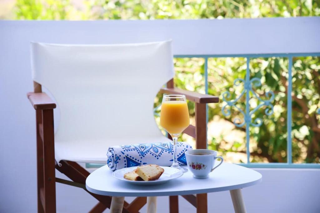 a table with a glass of orange juice and a plate of food at Apartment Simply 101 in Gázion
