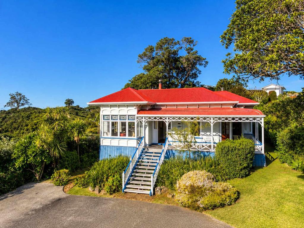 a house with a red roof and a driveway at Crescent Villa - Stay Waiheke in Ostend