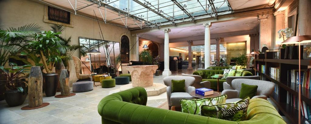 a room with green couches and plants in a building at Monaco &amp; Grand Canal in Venice