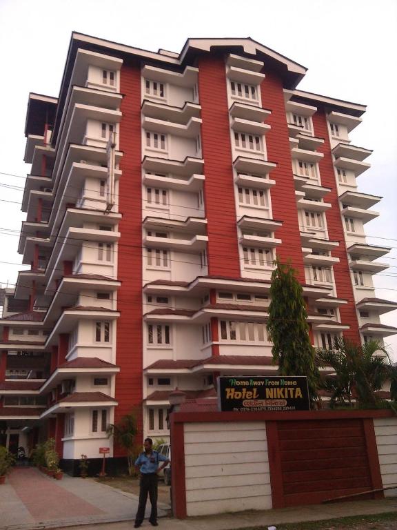 a person standing in front of a tall building at Hotel Nikita in Jorhat