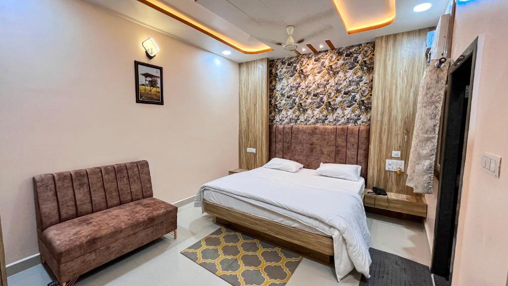 a bedroom with a bed and a chair at Hotel Ganga Ram in Chitrakoot