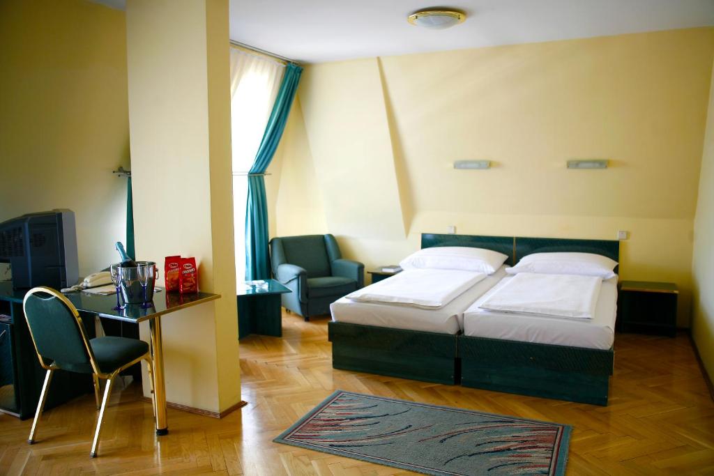 1 dormitorio con cama, escritorio y silla en Hotel Bara Budapest en Budapest