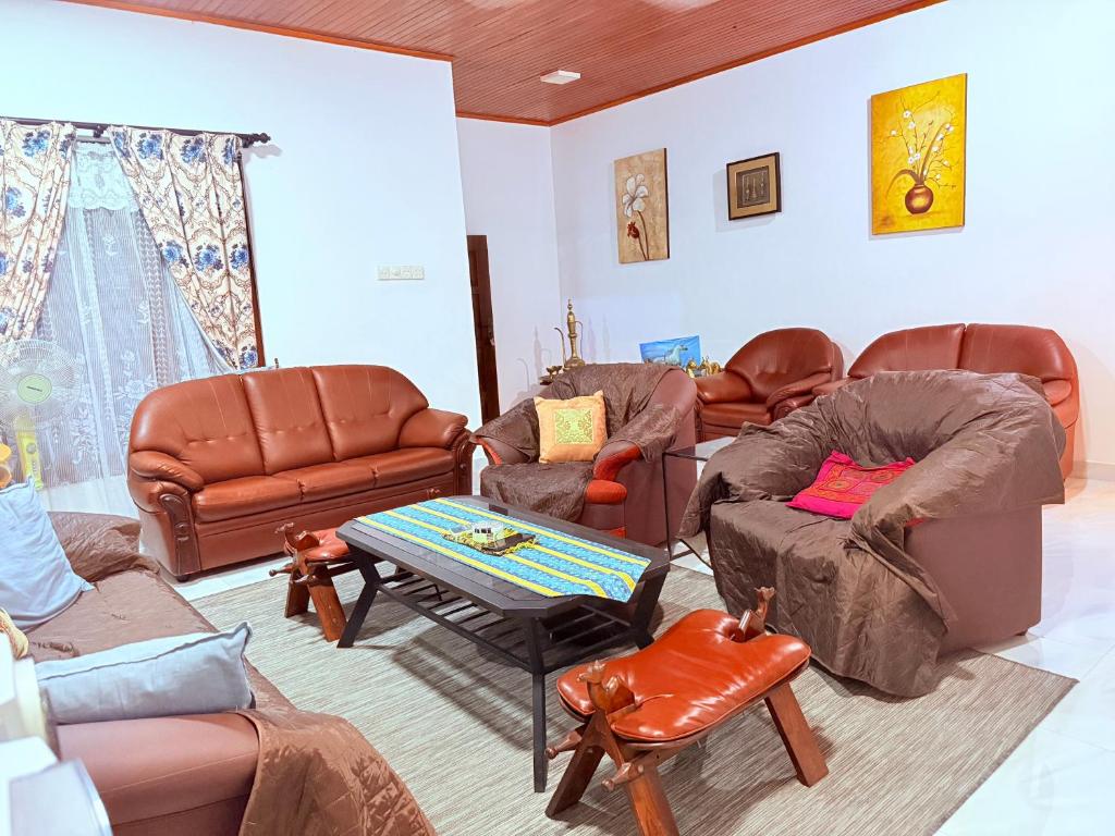 a living room with leather chairs and couches at Thalpe Gedara Villa in Talpe