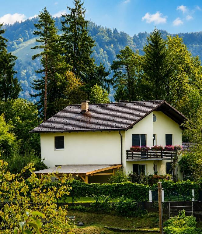 a white house with a black roof at Apartma Tanja bike-friendly in Limbuš