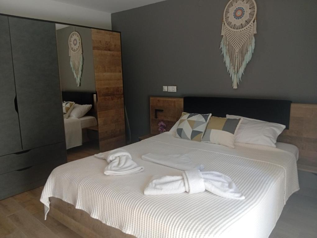 a bedroom with a bed with white towels on it at Spartines home in Votsi