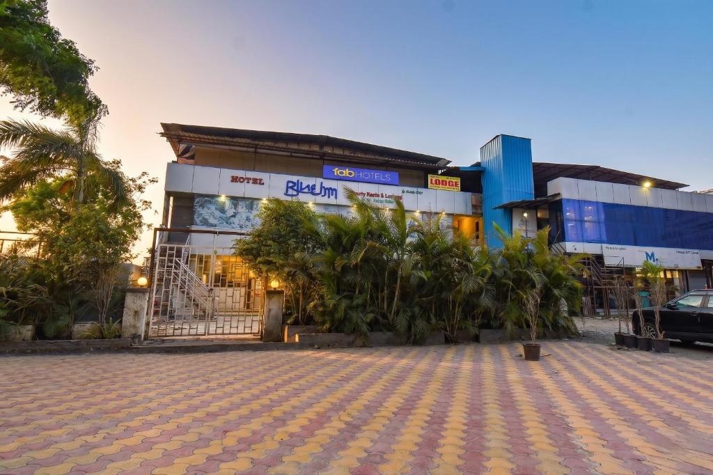 a building with a lot of trees in front of it at FabHotel Blue Inn I in Vagholi