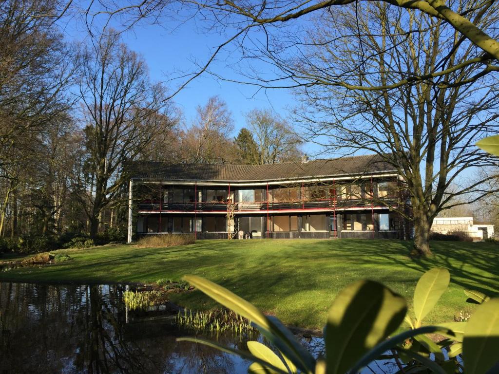 ein Haus mit einem Teich davor in der Unterkunft Villa am Hülser Berg nähe Düsseldorf in Krefeld