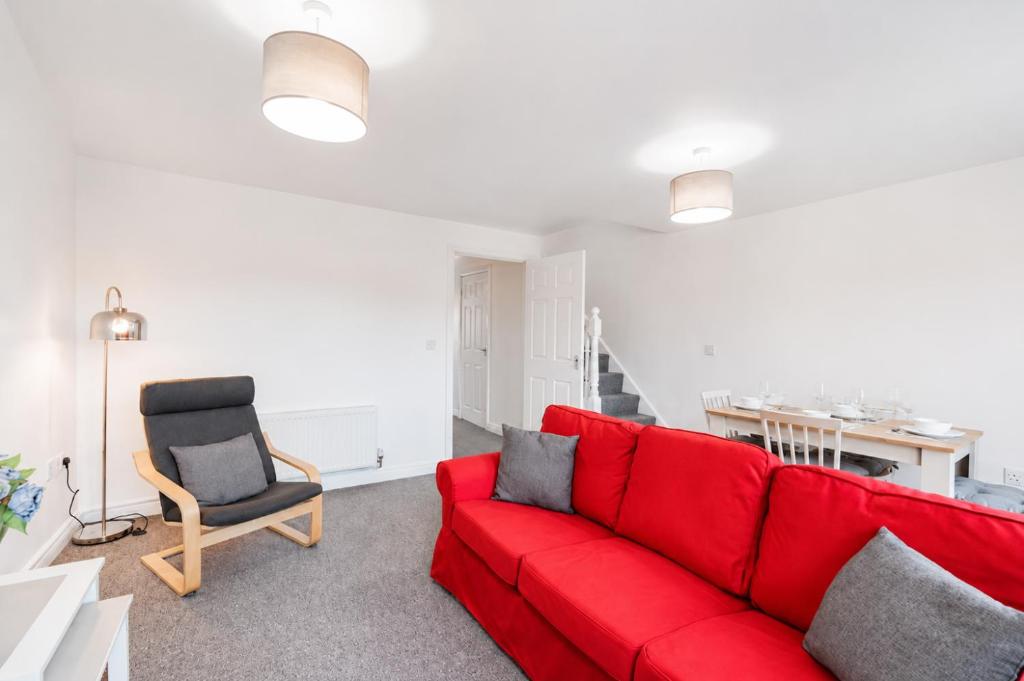 a living room with a red couch and a chair at Grantham Stays - Dexter - 3BR, Sleeps 5, Parking & WIFI in Grantham
