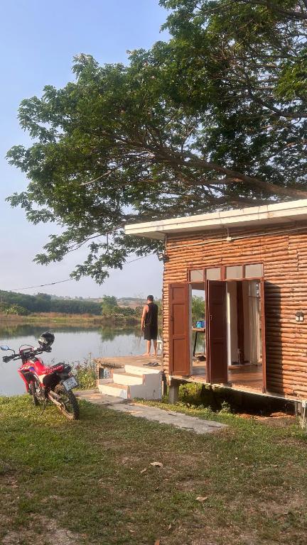 a house with a motorcycle parked in front of it at บ้านสวนริมอ่าง in Phayao