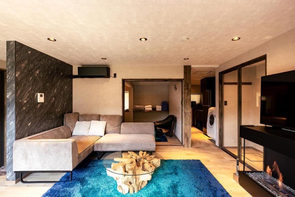 a living room with a couch and a tv at OOkami Villa in Omachi