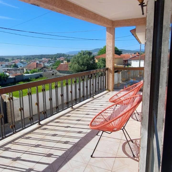 an orange hammock sitting on a balcony of a house at Meira House in Belinho