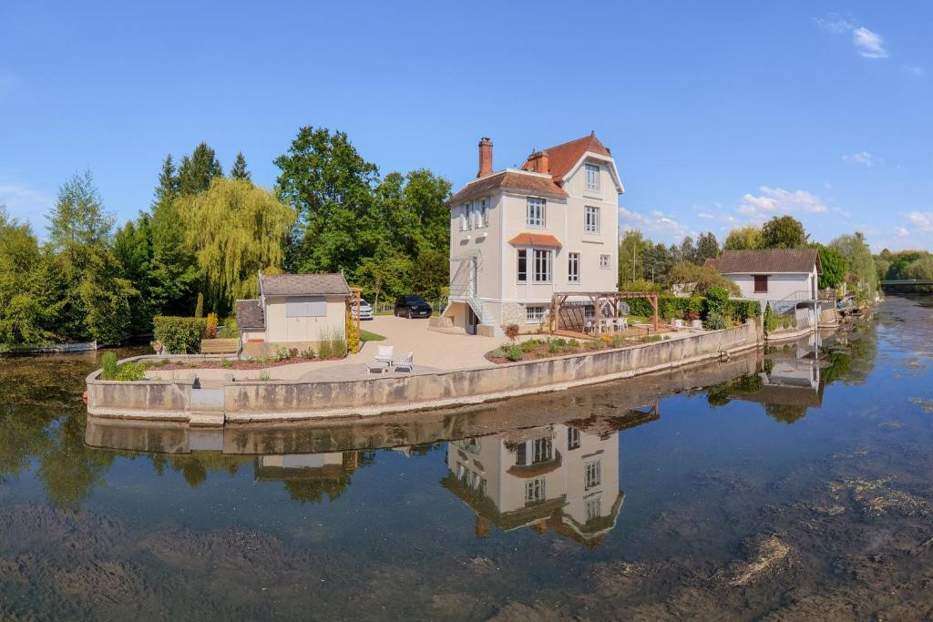 a house sitting on a bridge over a river at La Villa des Coccinelles in Olivet