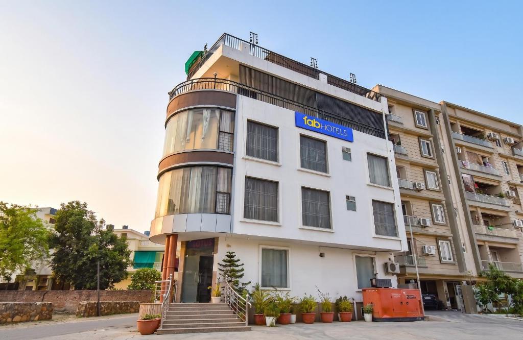 a white building with a blue sign on it at FabHotel Kirara - Nr Jaipur International Airport in Jaipur