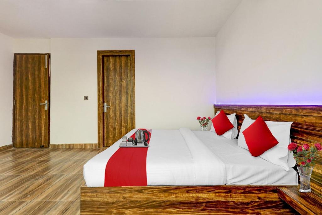 a bedroom with a large bed with red pillows at Hotel O Times Square in Indraprast