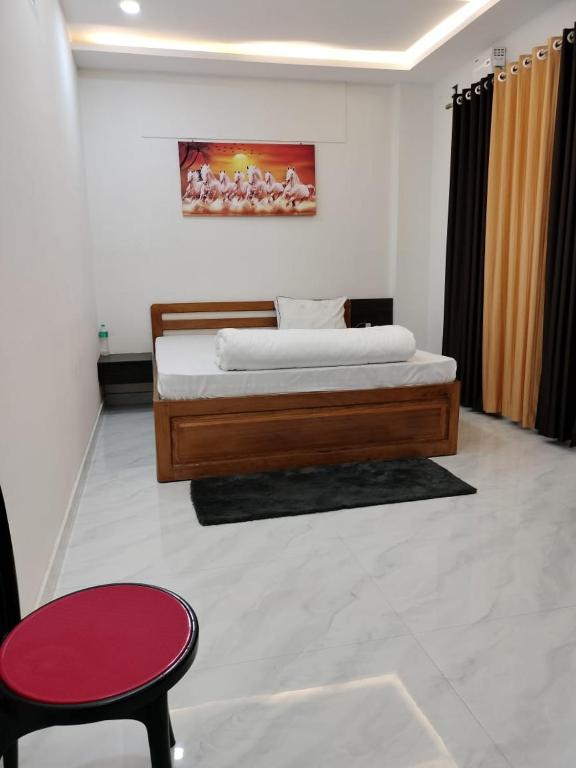 a bedroom with a large bed and a red stool at Hotel Raj in Letekujān