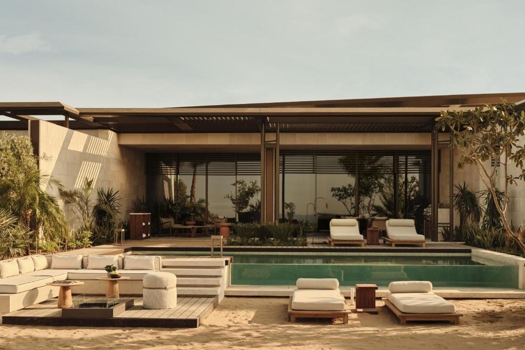 a house with a swimming pool with lounge chairs at Rosewood AMAALA in Amala
