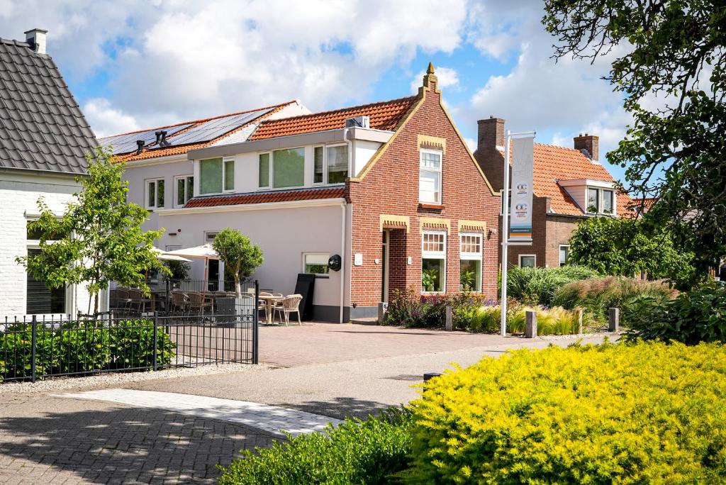 a house with a gate in front of it at Guesthouse Ouddorp Connection in Ouddorp