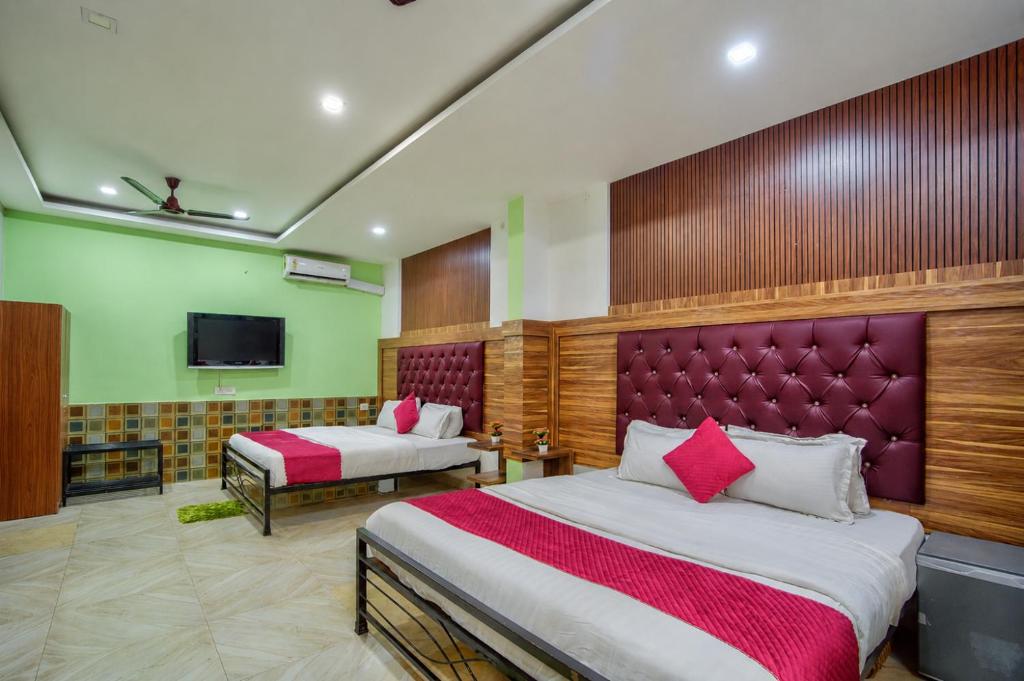 a hotel room with two beds and a tv at Hotel bright house in Calangute