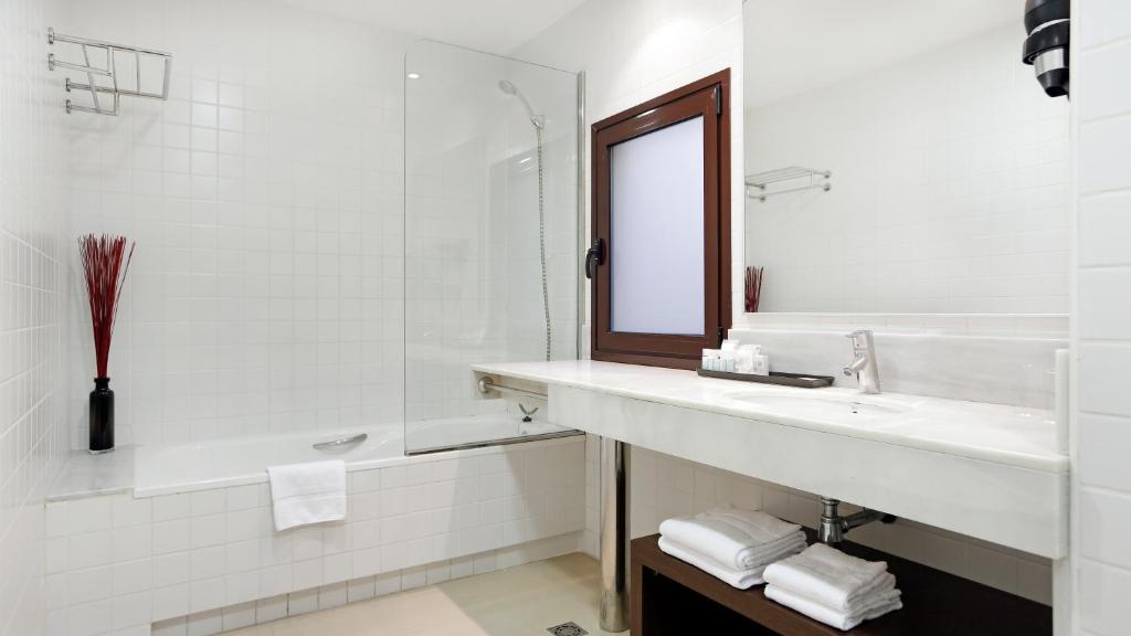 a white bathroom with a sink and a mirror at Arc La Rambla in Barcelona