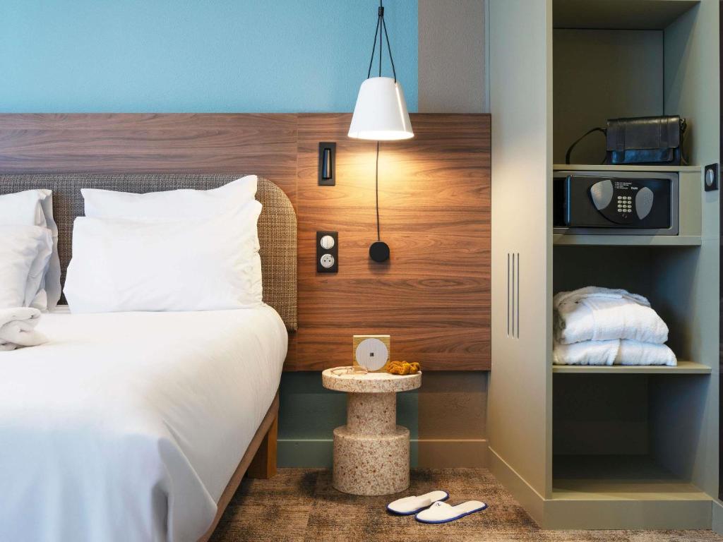 a hotel room with a bed and a microwave at Novotel Suites Nancy Centre in Nancy