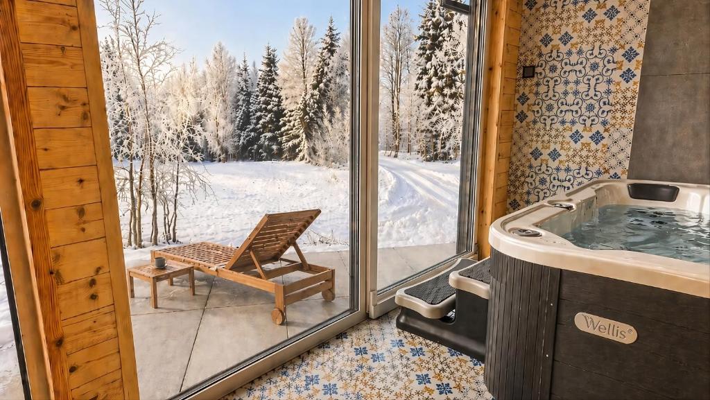 a bathroom with a tub and a chair next to a window at Domek SPA z sauną i jacuzzi - Level780 in Koszarawa
